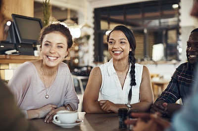 Buy stock photo Cropped shot of a diverse group of friends sitting together and bonding in a coffee shop