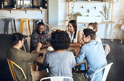Buy stock photo Cropped shot of a diverse group of friends sitting together and bonding in a coffee shop