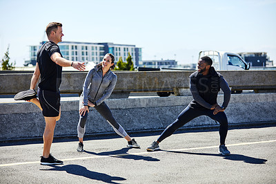 Buy stock photo Shot of a fitness group stretching before their run