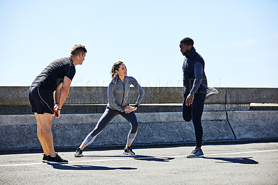 Buy stock photo Shot of a fitness group stretching before their run