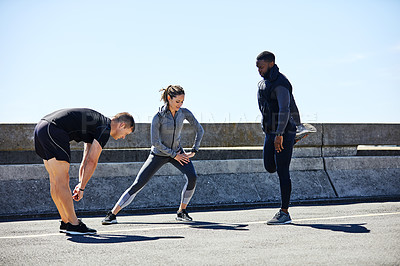 Buy stock photo Shot of a fitness group stretching before their run