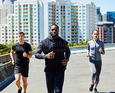 Buy stock photo Shot of a group of sporty young people out for a run in the city