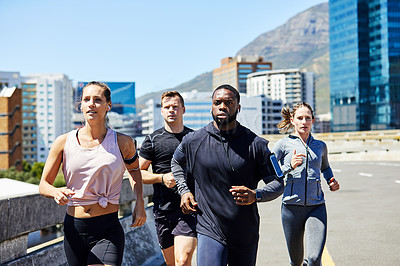 Buy stock photo Shot of a group of sporty young people out for a run in the city