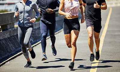 Buy stock photo Cropped shot of a group of sporty young people out for a run in the city