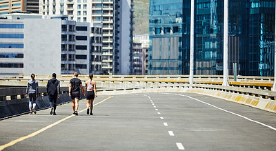 Buy stock photo Shot of a group of sporty young people out for a run in the city