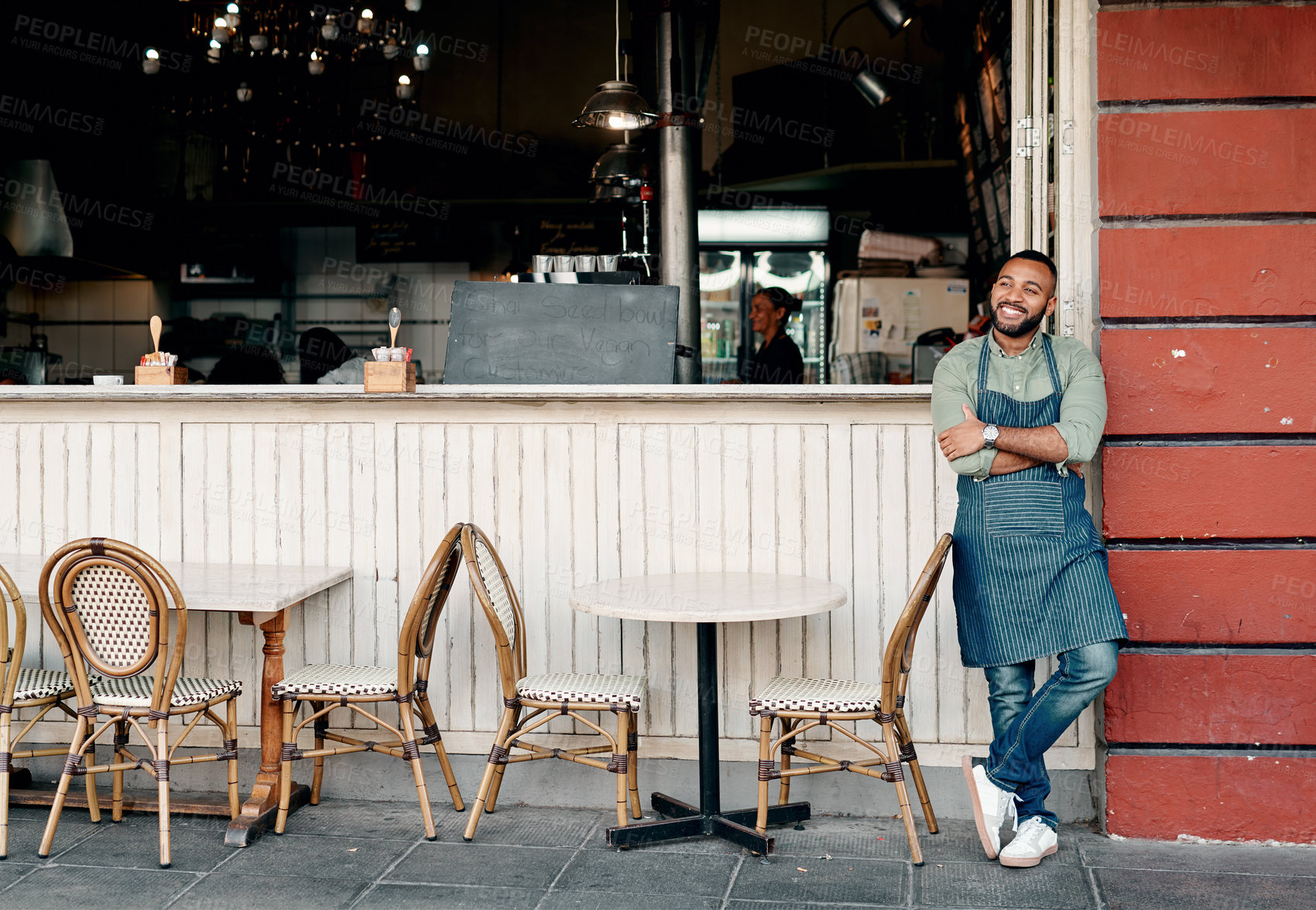 Buy stock photo Shot of a young man standing outside his cafe