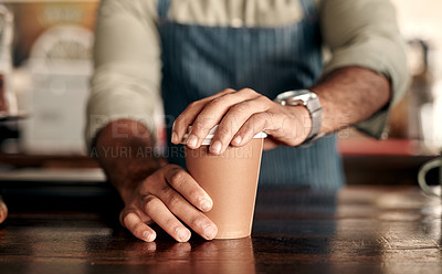 Buy stock photo Closeup shot of a barista sealing a lid on a coffee cup in a cafe