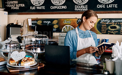 Buy stock photo Shot of a young woman writing notes while working in a cafe