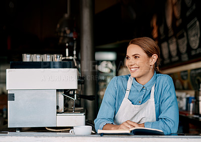 Buy stock photo Shot of a young woman writing notes while working in a cafe