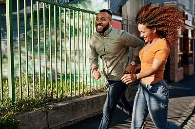 Buy stock photo Shot of a young couple walking together in the city