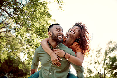Buy stock photo Shot of a young man giving his girlfriend a piggyback ride outdoors