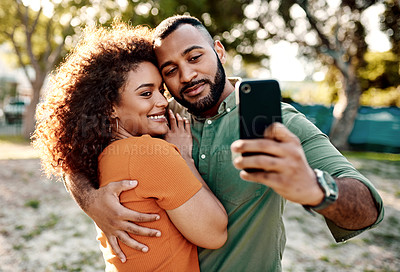 Buy stock photo Shot of a young couple taking selfies together outdoors