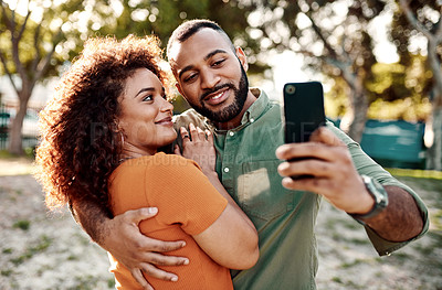 Buy stock photo Shot of a young couple taking selfies together outdoors