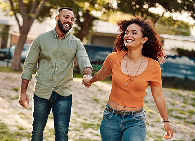 Buy stock photo Shot of a young couple walking together in a park