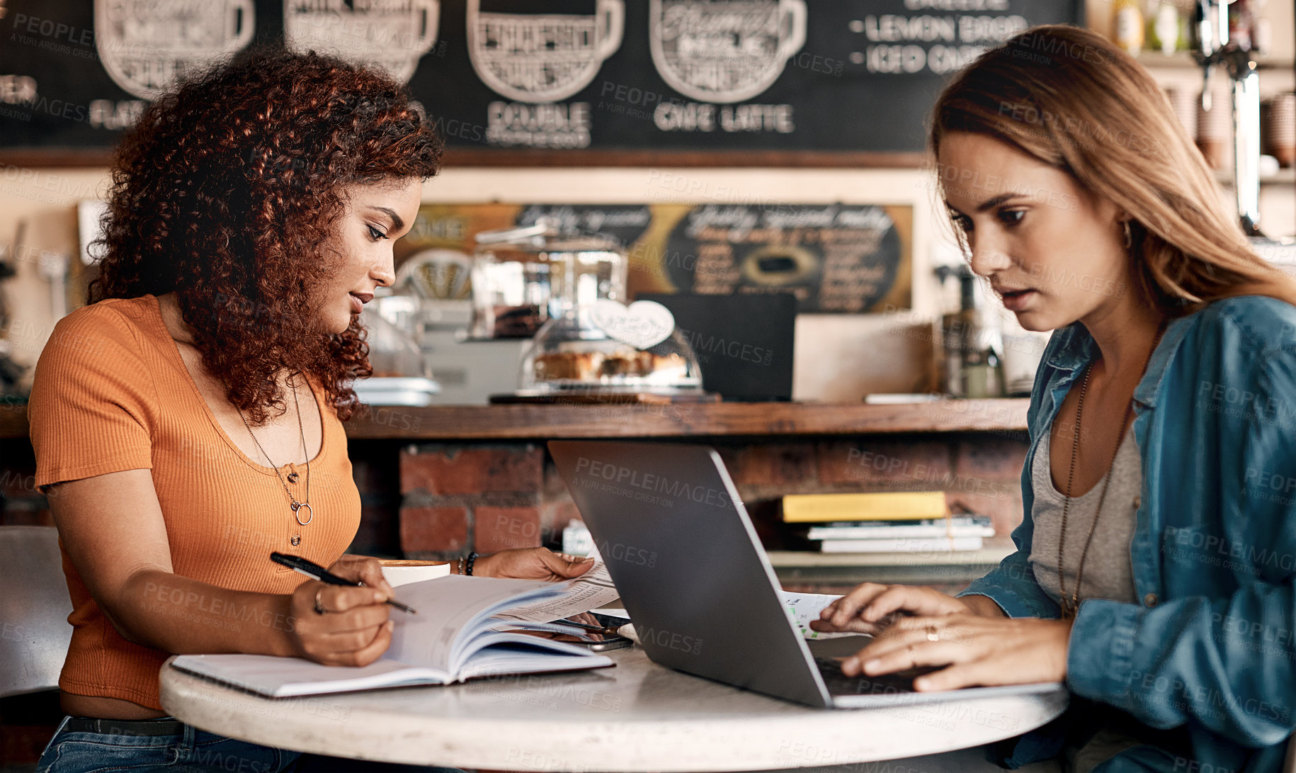 Buy stock photo Shot of two young women having a meeting in a cafe