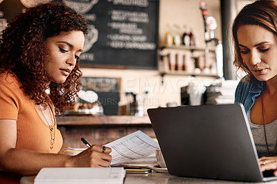 Buy stock photo Shot of two young women having a meeting in a cafe