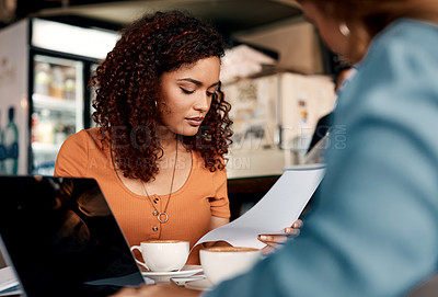 Buy stock photo Shot of two young women having a meeting in a cafe