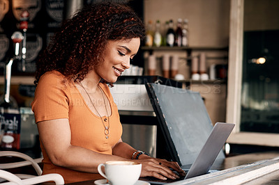 Buy stock photo Shot of a young woman working on a laptop in a cafe