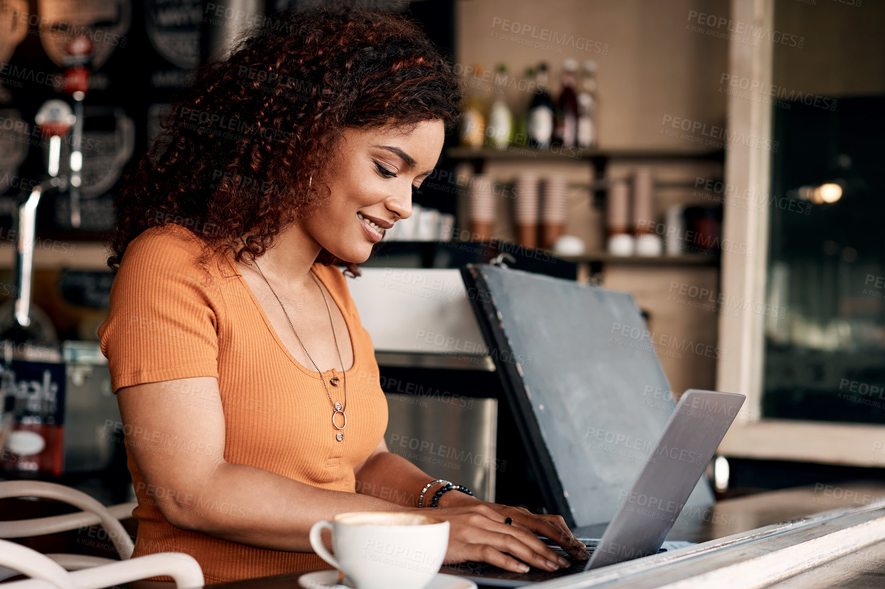 Buy stock photo Shot of a young woman working on a laptop in a cafe