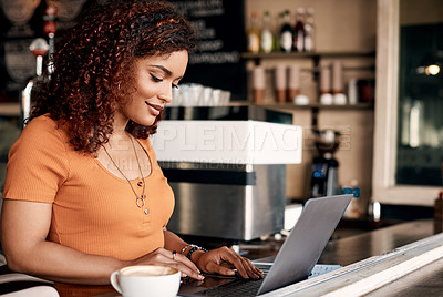 Buy stock photo Shot of a young woman working on a laptop in a cafe