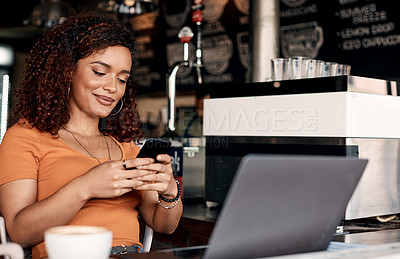Buy stock photo Shot of a young woman using a cellphone in a cafe