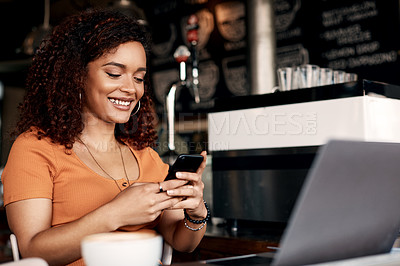 Buy stock photo Shot of a young woman using a cellphone in a cafe