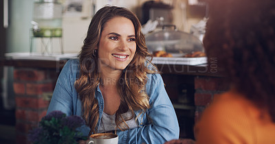 Buy stock photo Shot of a young woman chatting to her friend in a cafe