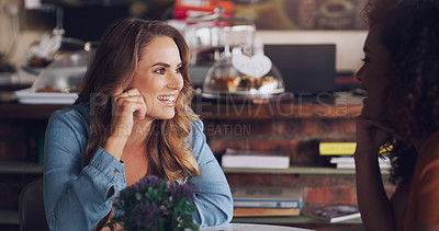 Buy stock photo Shot of a young woman chatting to her friend in a cafe