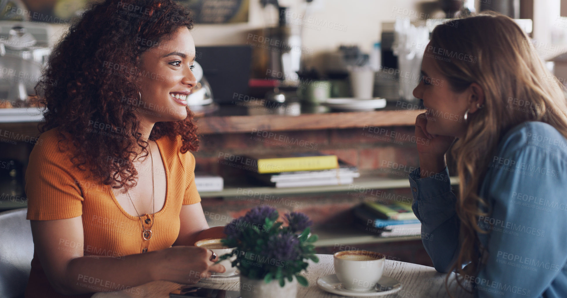 Buy stock photo Shot of two young women chatting in a cafe
