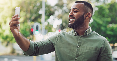 Buy stock photo Shot of a young man using a cellphone while out in the city