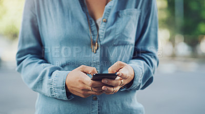 Buy stock photo Closeup shot of an unrecognisable woman using a cellphone while out in the city