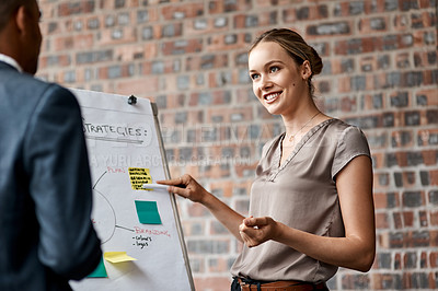 Buy stock photo Shot of an attractive young businesswoman standing with a coworker and using a visual aid for a presentation