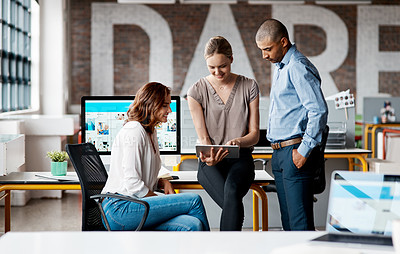 Buy stock photo Shot of a group of businesspeople using a digital tablet together in an office