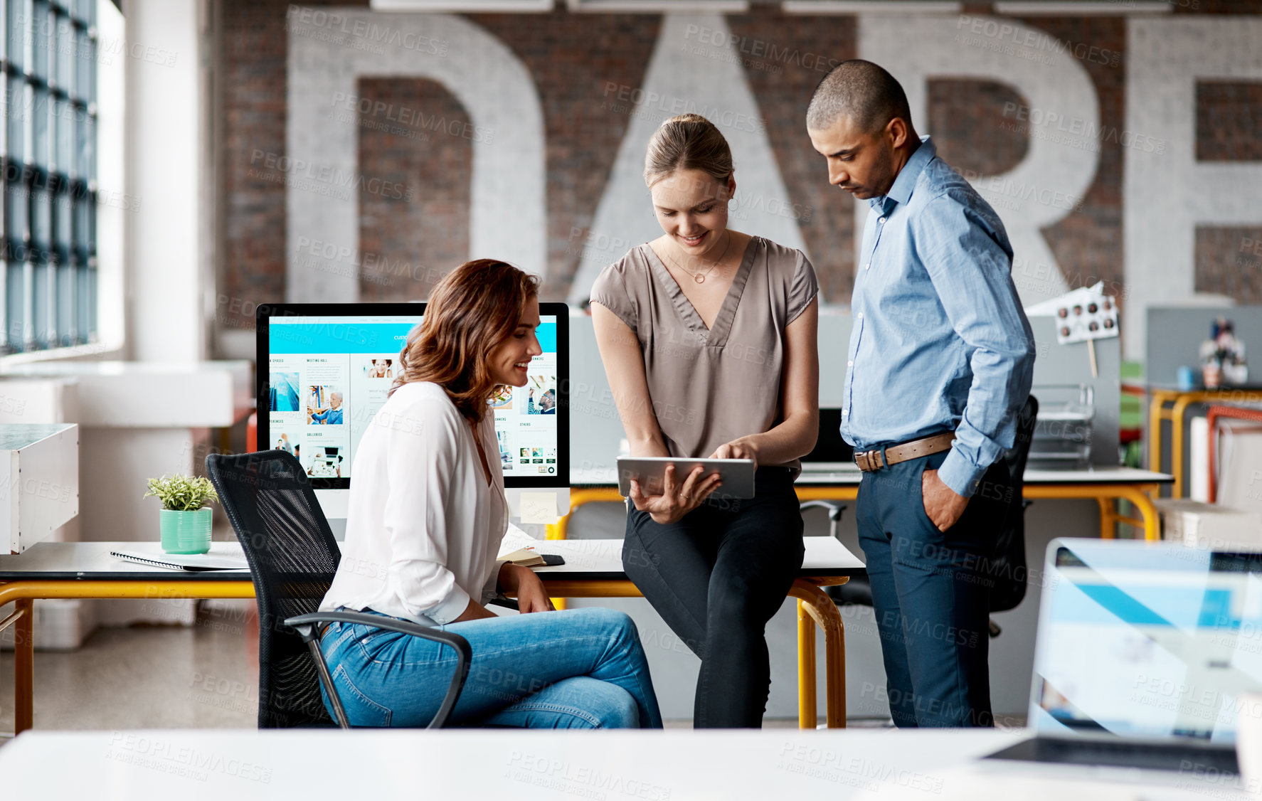 Buy stock photo Shot of a group of businesspeople using a digital tablet together in an office