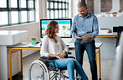 Buy stock photo Shot of two businesspeople using a digital tablet together in an office