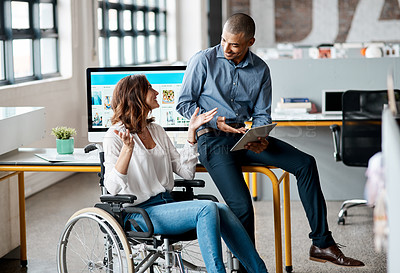 Buy stock photo Shot of two businesspeople using a digital tablet together in an office
