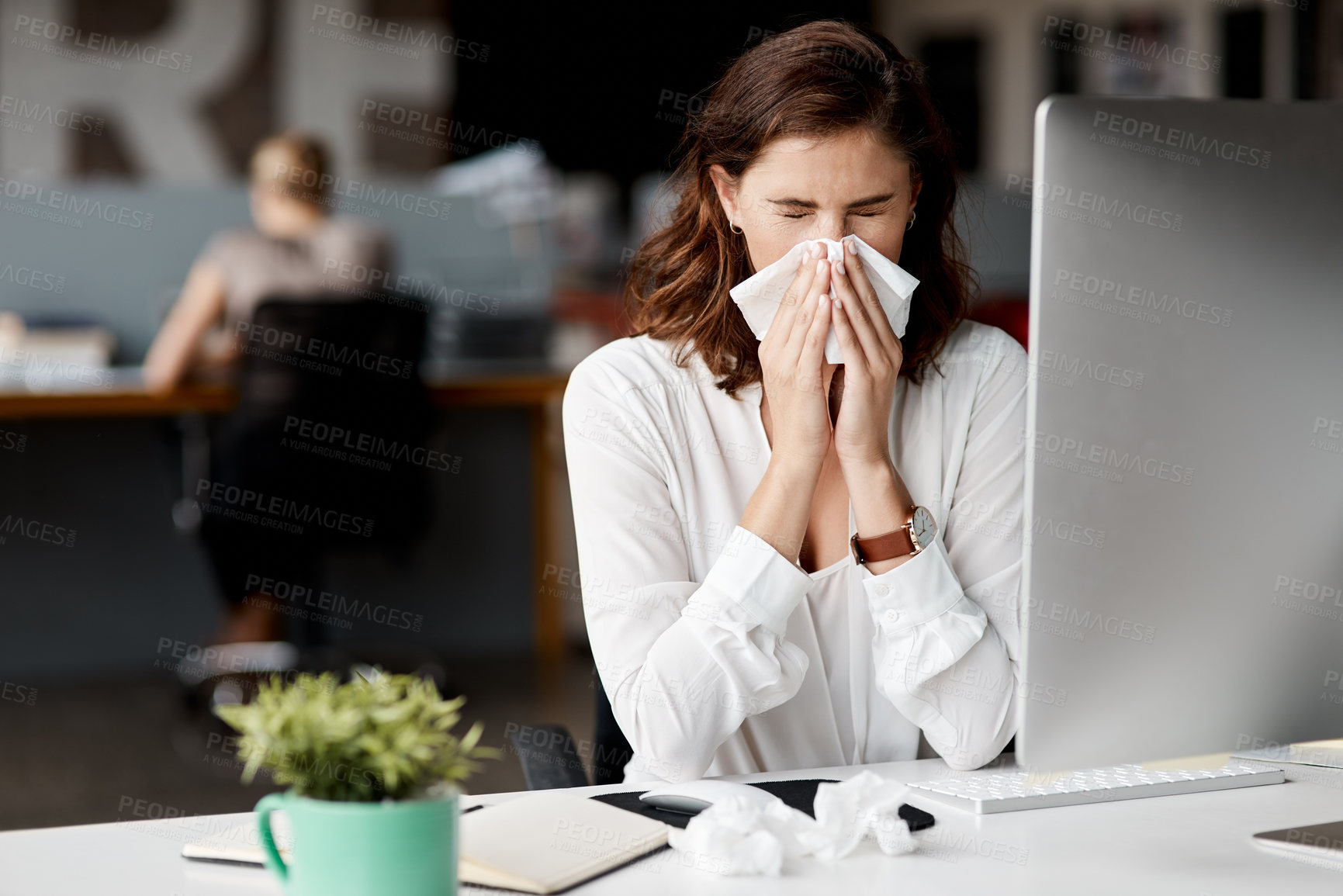 Buy stock photo Shot of an attractive young businesswoman sitting alone at her desk and feeling sick
