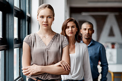 Buy stock photo Shot of a diverse group of businesspeople standing in a line behind each other in the office during the day