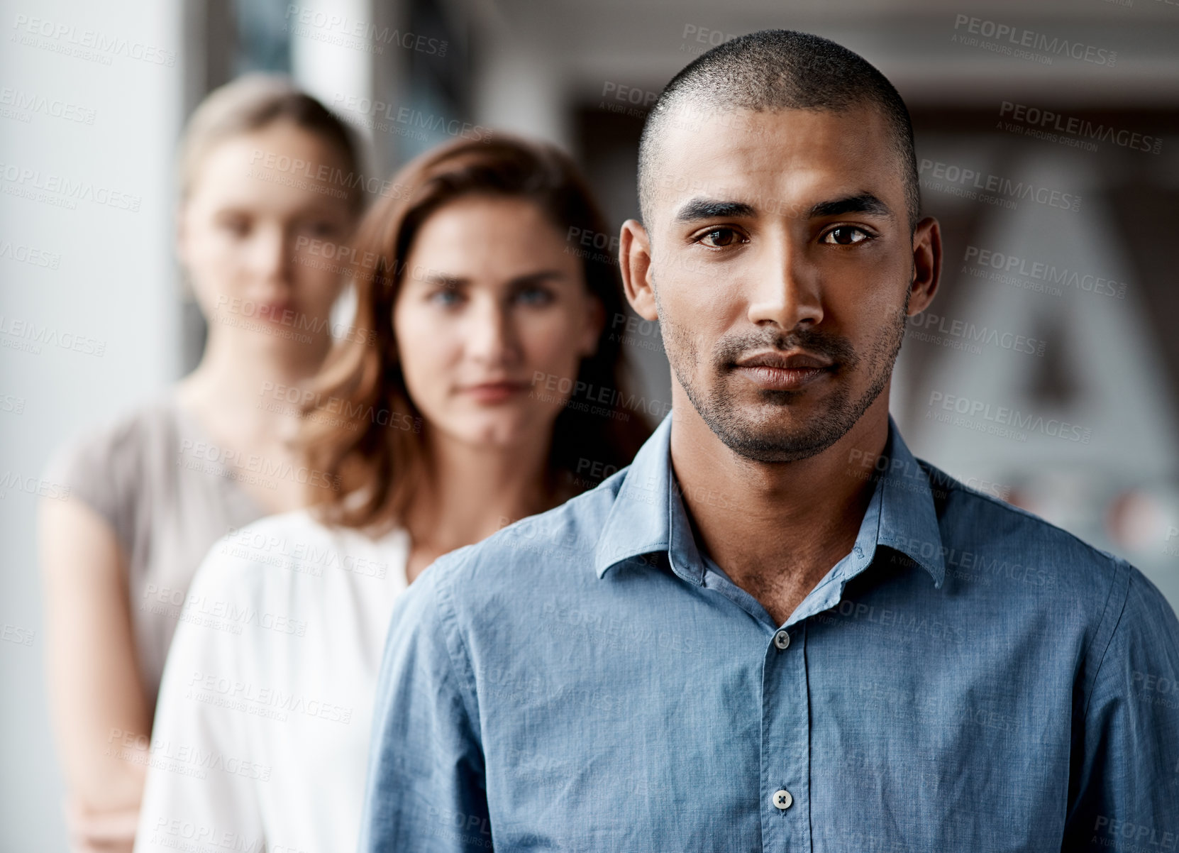 Buy stock photo Shot of a diverse group of businesspeople standing in a line behind each other in the office during the day
