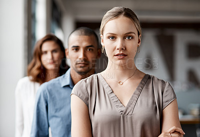 Buy stock photo Shot of a diverse group of businesspeople standing in a line behind each other in the office during the day