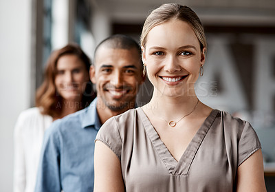Buy stock photo Shot of a diverse group of businesspeople standing in a line behind each other in the office during the day