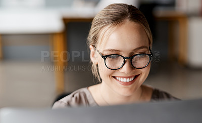 Buy stock photo Shot of an attractive young businesswoman sitting alone in the office and using her computer
