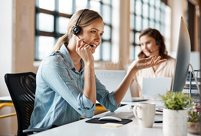 Buy stock photo Shot of a young businesswoman wearing a headset while working on a computer in an office