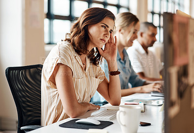 Buy stock photo Shot of a young businesswoman looking stressed out while working on a computer in an office