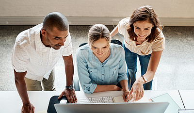 Buy stock photo High angle shot of a group of businesspeople working together on a computer in an office