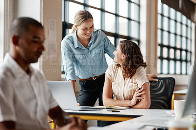 Buy stock photo Shot of two businesspeople working together on a laptop in an office
