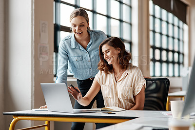 Buy stock photo Shot of two businesspeople working together on a laptop in an office