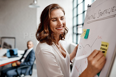 Buy stock photo Shot of a young businesswoman writing notes on a whiteboard in an office