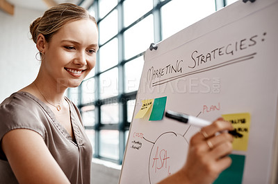 Buy stock photo Shot of a young businesswoman writing notes on a whiteboard in an office