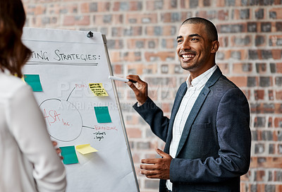 Buy stock photo Shot of a young businessman presenting notes on a whiteboard in an office